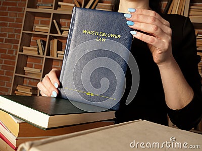 Attorney holds WHISTLEBLOWER LAW book. As aÂ whistleblowerÂ you`re protected byÂ lawÂ - you should not be treated unfairly or los Stock Photo